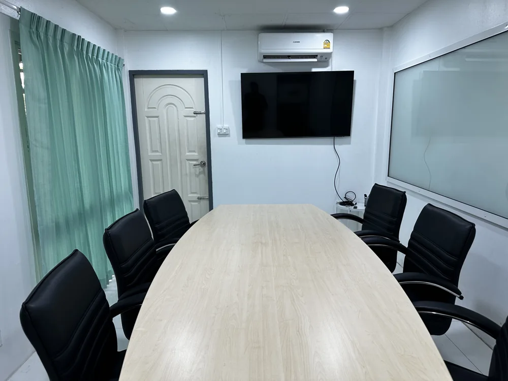 Meeting room with a table, chairs, screen, and whiteboard